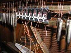 Photo of solenoides beneath the keyboard of a piano