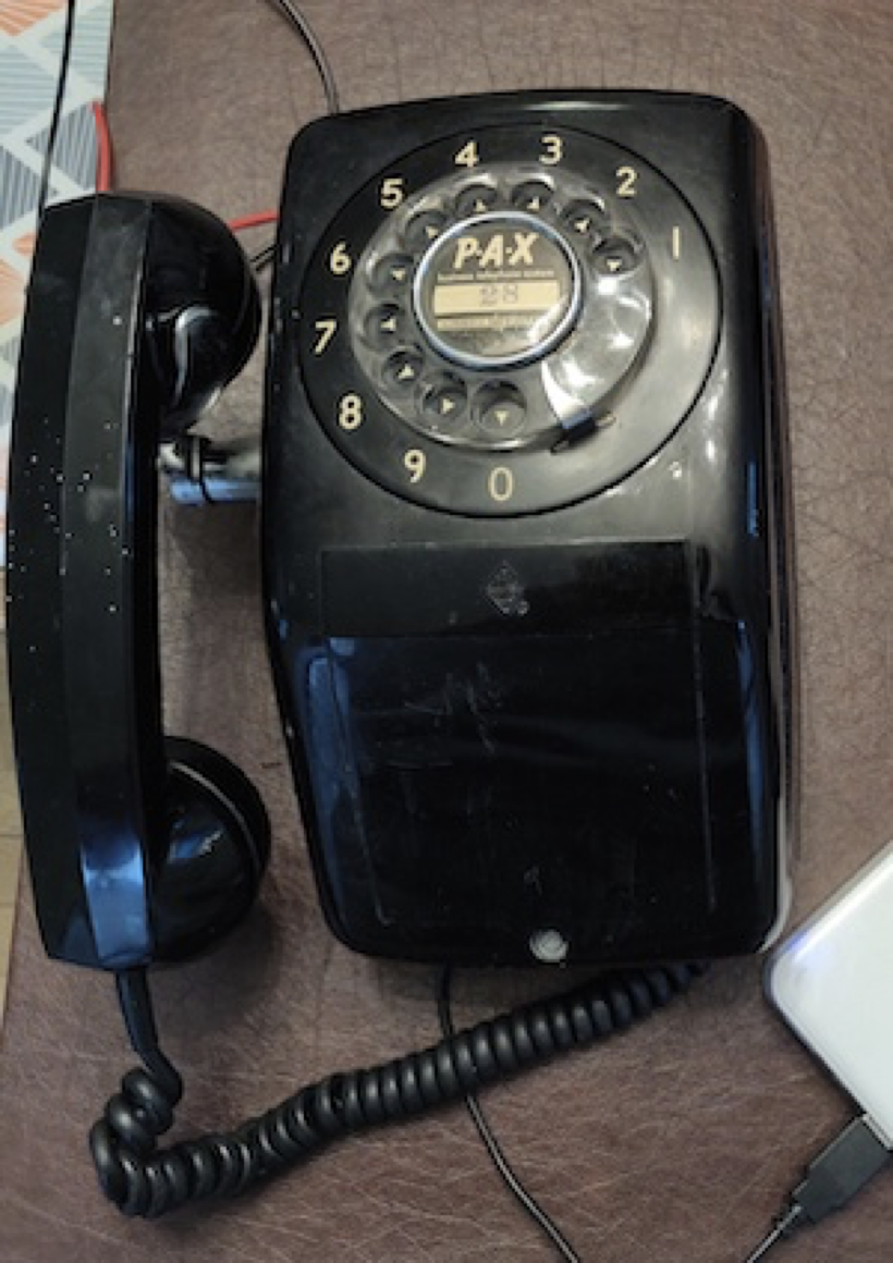 A photo of a wall-mounted rotary phone