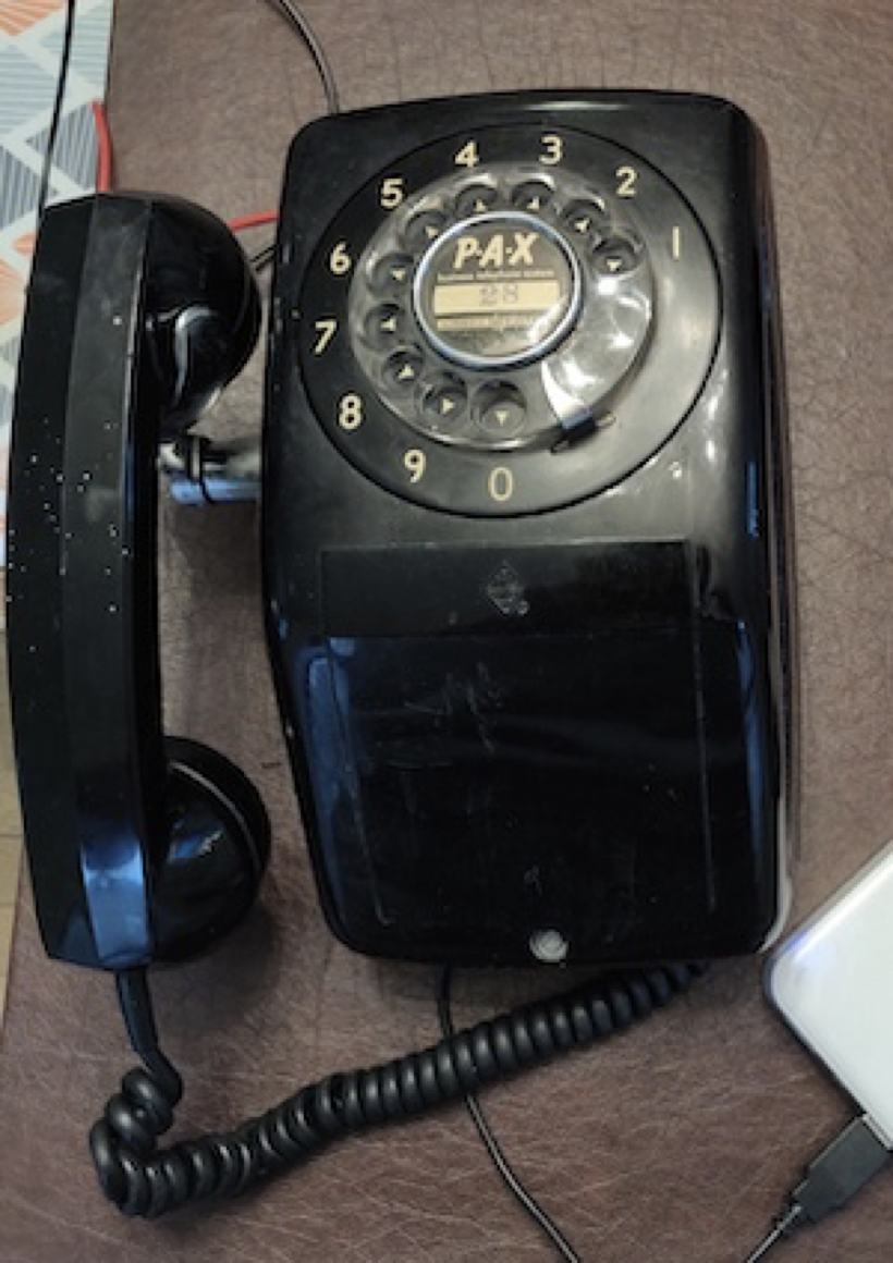 A wall-mounted rotary phone, used as a light dimmer